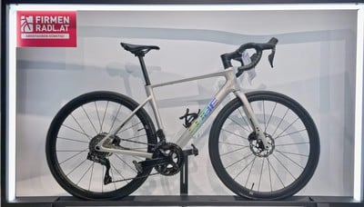 Ein graues Cube Rennrad mit Logo auf dem Rahmen steht im Geschäft.
