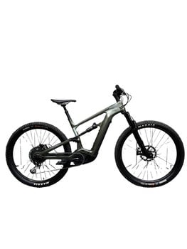 Ein graugrünes vollgefedertes E-Bike mit schwarzen Maxxis-Reifen.