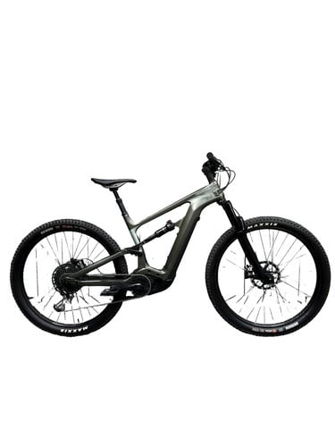 Ein graugrünes vollgefedertes E-Bike mit schwarzen Maxxis-Reifen.