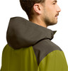 Mann in grüner Kapuzenjacke, Seitenansicht.