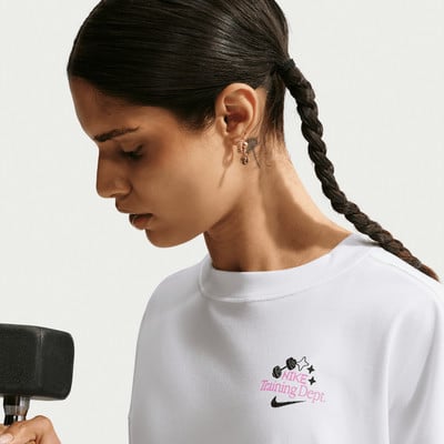 Nő fehér pólóban Nike logóval és súlyzóval.