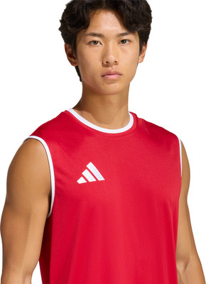 Ein junger Mann in einem roten Tanktop mit Adidas-Logo auf weißem Hintergrund. Ein junger Mann in einem roten Tanktop mit Adidas-Logo auf weißem Hintergrund.