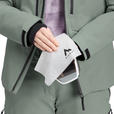 Eine Person reinigt eine Skibrille mit einem McKinley-Logo-Tuch.