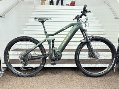 Ein grünes Haibike E-Bike mit Federung auf einer Treppe. Ein grünes Haibike E-Bike mit Federung auf einer Treppe.