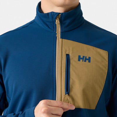 Blaue Jacke mit brauner Tasche und HH-Logo auf der Brust. Blaue Jacke mit brauner Tasche und HH-Logo auf der Brust.