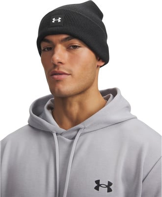 Ein Mann mit schwarzer Mütze und grauer Kapuzenjacke mit Under Armour Logo. Ein Mann mit schwarzer Mütze und grauer Kapuzenjacke mit Under Armour Logo.