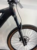 Schwarzes E-Mountainbike mit RockShox-Federung, HEPHA-Logo und braunen Reifen.