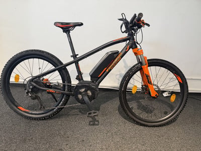 Schwarzes E-Bike mit orangefarbenen Akzenten an Rahmen und Gabel. Schwarzes E-Bike mit orangefarbenen Akzenten an Rahmen und Gabel.