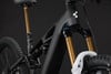 Detail eines Mountainbike mit Federung und goldener Gabel.