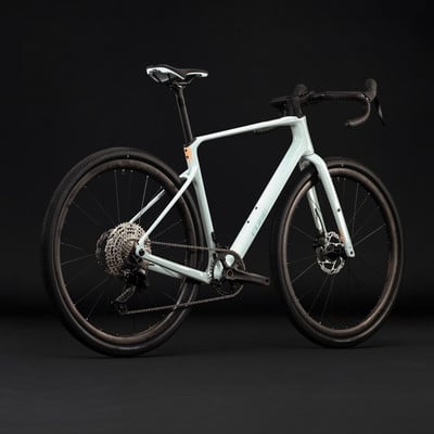 Hellblau-graues Gravelbike mit schwarzen Rädern und Details. Hellblau-graues Gravelbike mit schwarzen Rädern und Details.