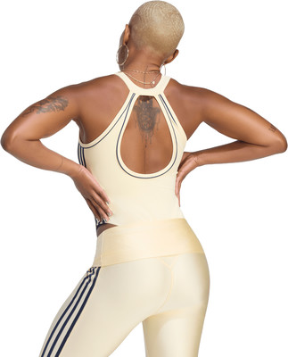 Frau in cremefarbener Sport-Crop-Top und Leggings mit dunklen Streifen. Frau in cremefarbener Sport-Crop-Top und Leggings mit dunklen Streifen.