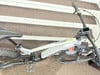 Ein Genesis E-Mountainbike mit Display und Federung auf einer Treppe.