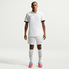 Ein Mann in einem weißen Fußballtrikot und Shorts mit schwarzen Details.