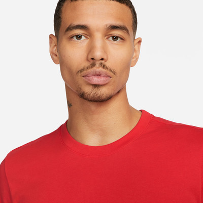 Ein Mann mit kurzen dunklen Haaren und Schnurrbart trägt ein rotes T-Shirt. Ein Mann mit kurzen dunklen Haaren und Schnurrbart trägt ein rotes T-Shirt.