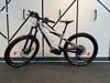 Graues E-Mountainbike mit Federung und breiten Reifen.