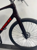 Detail eines dunkelroten Trek-Fahrradrahmens mit Vorderreifen.