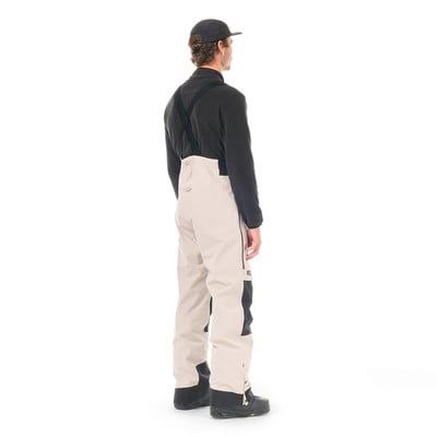 Mann in schwarzem Oberteil und beiger Latzhose. Mann in schwarzem Oberteil und beiger Latzhose.