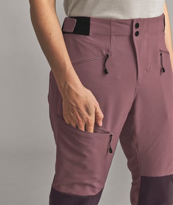 Detail einer Damen-Hose mit einer Tasche, in die eine Hand hineinragt. Detail einer Damen-Hose mit einer Tasche, in die eine Hand hineinragt.