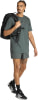Ein Mann mit Rucksack trägt ein dunkelgrünes T-Shirt und Shorts.