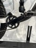 Detail eines Mountainbikes mit Dämpfer und Kurbel auf weißem Hintergrund.