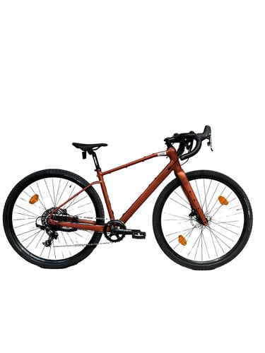 Ein orangefarbenes Gravelbike mit schwarzen Rädern und Lenker auf weißem Hintergrund.