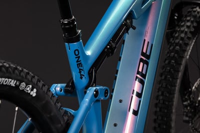 Detail eines blauen Mountainbike-Rahmens mit Dämpfer und CUBE-Schriftzug. Detail eines blauen Mountainbike-Rahmens mit Dämpfer und CUBE-Schriftzug.