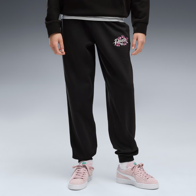 Schwarze Jogginghose mit PUMA-Logo und Blumenmotiv, rosa Sneaker. Schwarze Jogginghose mit PUMA-Logo und Blumenmotiv, rosa Sneaker.