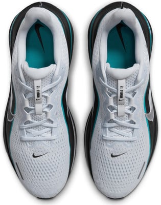 Fehér Nike futócipők fekete és türkiz részletekkel, felülnézetből. Fehér Nike futócipők fekete és türkiz részletekkel, felülnézetből.