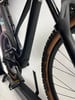 Detail eines modernen schwarzen E-Bikes mit braunen Rädern im Ständer.