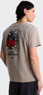 Mann in einem beigefarbenen T-Shirt mit einem Aufdruck eines Rucksacktouristen.
