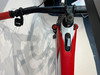 Detail eines E-Mountainbikes mit rot-weißem Rahmen und Display.