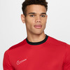 Ein Mann in einem roten T-Shirt mit weißem Nike-Logo.