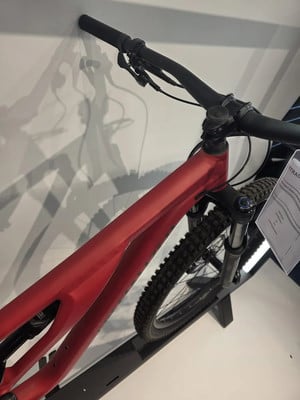 Ein rotes Mountainbike mit schwarzem Lenker und Dämpfer im Ausstellungsraum. Ein rotes Mountainbike mit schwarzem Lenker und Dämpfer im Ausstellungsraum.