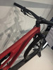 Ein rotes Mountainbike mit schwarzem Lenker und Dämpfer im Ausstellungsraum.