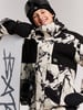 Junge in einer Winterjacke und Skibrille mit Snowboard.