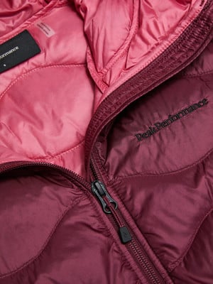 Detail einer Peak Performance Daunenjacke mit rosa Futter und dunkelweinrotem Äußeren.