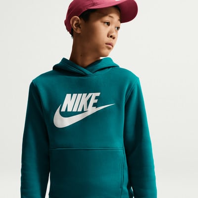 Junge in einem dunkel-türkisfarbenen Nike-Hoodie und einer weinroten Kappe.