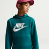 Junge in einem dunkel-türkisfarbenen Nike-Hoodie und einer weinroten Kappe.