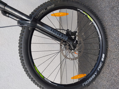 Nahaufnahme eines Mountainbikes mit RockShox-Federung und Schwalbe Nobby Nic Reifen.