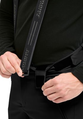 Ein Mann passt schwarze Hosenträger an schwarzer Hose an. Ein Mann passt schwarze Hosenträger an schwarzer Hose an.