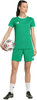 Eine Frau im grünen Fußballtrikot und Shorts hält einen Ball.