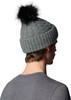 Ein Mann von hinten trägt eine graue Strickmütze mit schwarzem Bommel.