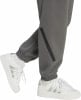 Graue Jogginghose mit schwarzem Streifen und weiße Sneaker mit Streifen.