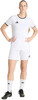 Eine Frau im weißen Fußballtrikot und Shorts mit schwarzen Streifen und Fußballschuhen.