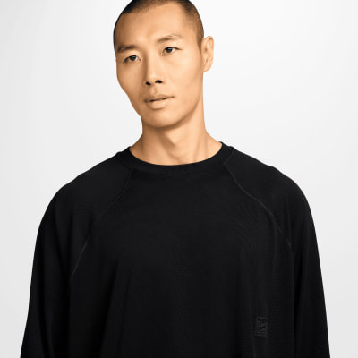 Ein Mann in einem schwarzen Langarmshirt mit Nike ACG Logo.