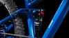 Detail des Hinterbaus und des Dämpfers eines Mountainbikes mit blauem Rahmen.