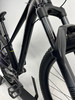 Nahaufnahme der Vordergabel und des Rahmens eines schwarzen Mountainbikes.