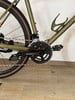 Detail eines Fahrrads mit Kette und Kurbelgarnitur auf Holzboden.