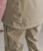 Detail einer Jacke mit GORE-TEX-Logo und beiger Hose.