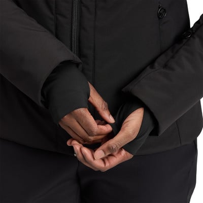 Detail der Hände in schwarzen Handschuhen mit Daumenlöchern und einer schwarzen Jacke.